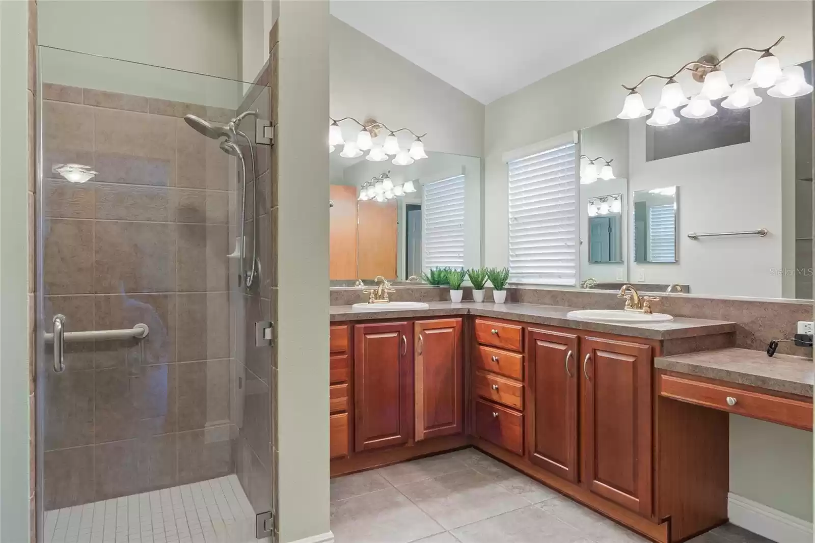 Spacious Primary Bath with double vanities, tiled walk in shower, and separate water closet