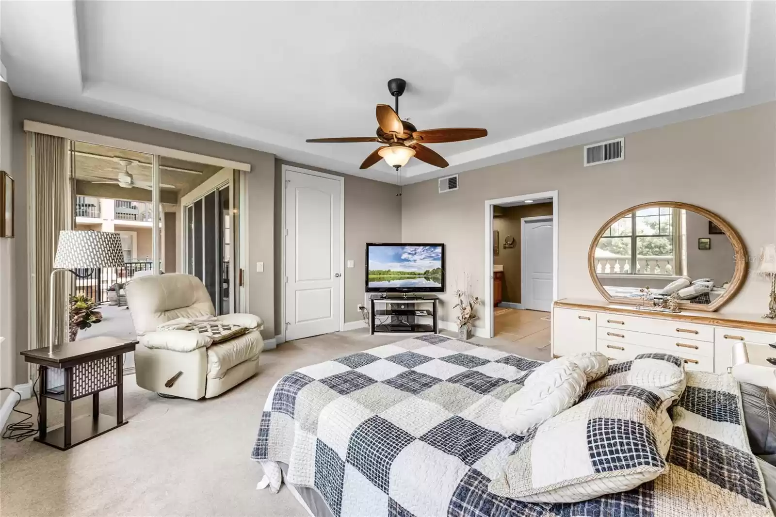 A tray ceiling adds a unique touch to the style of the primary bedroom.