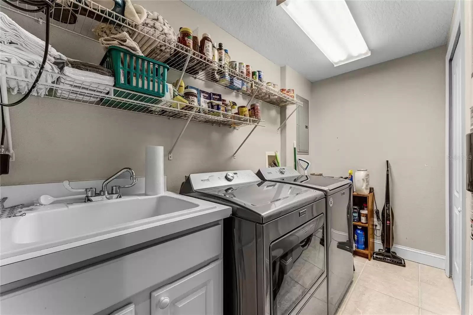 The laundry room features a sink with cabinet space for storage.