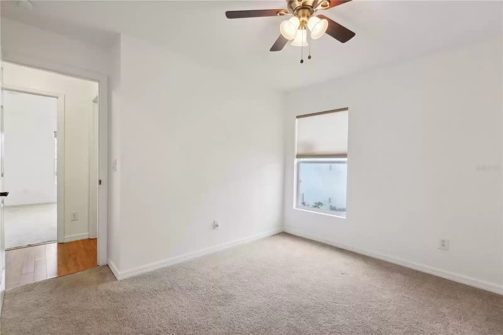 Another perspective of the second bedroom, highlighting its spacious layout and natural light