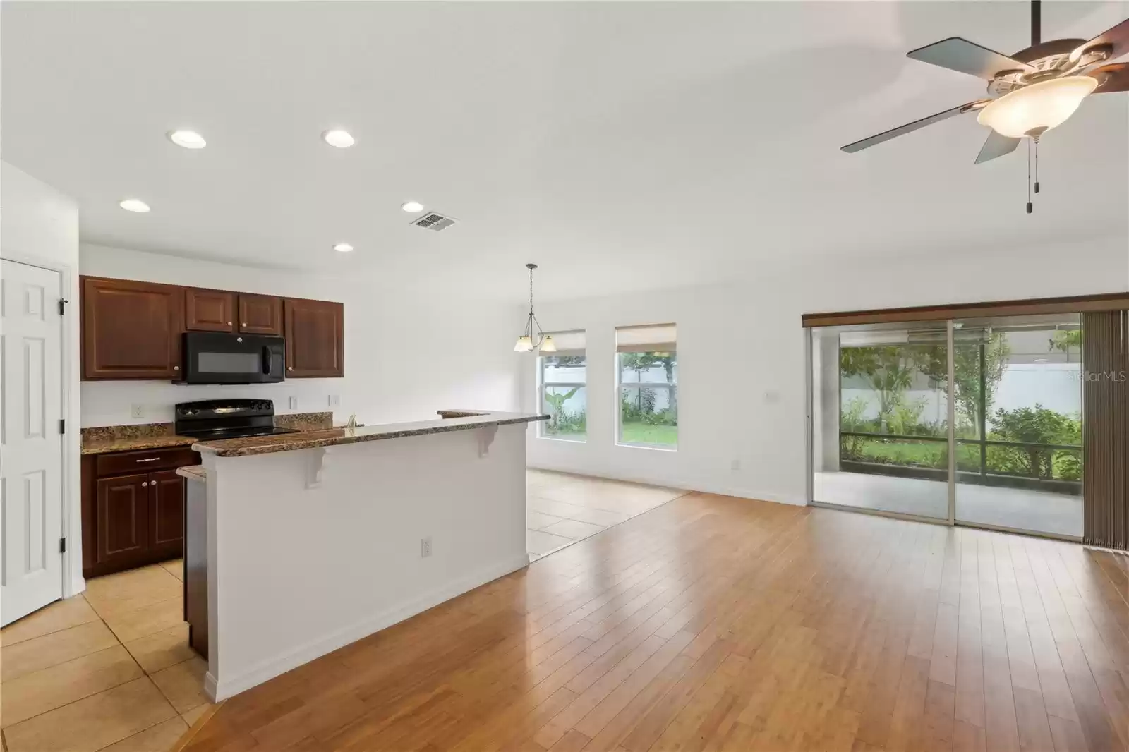 Natural light pours into the dining area through two large windows and the expansive patio sliders