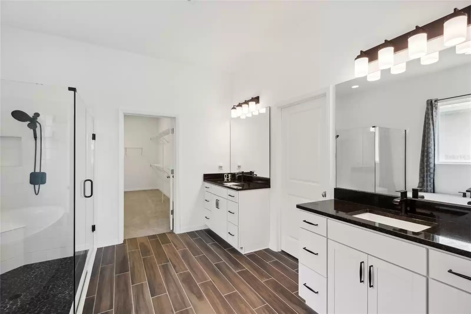 Stylish master bath with dual vanities and sinks, full shower and attractive soaking tub.