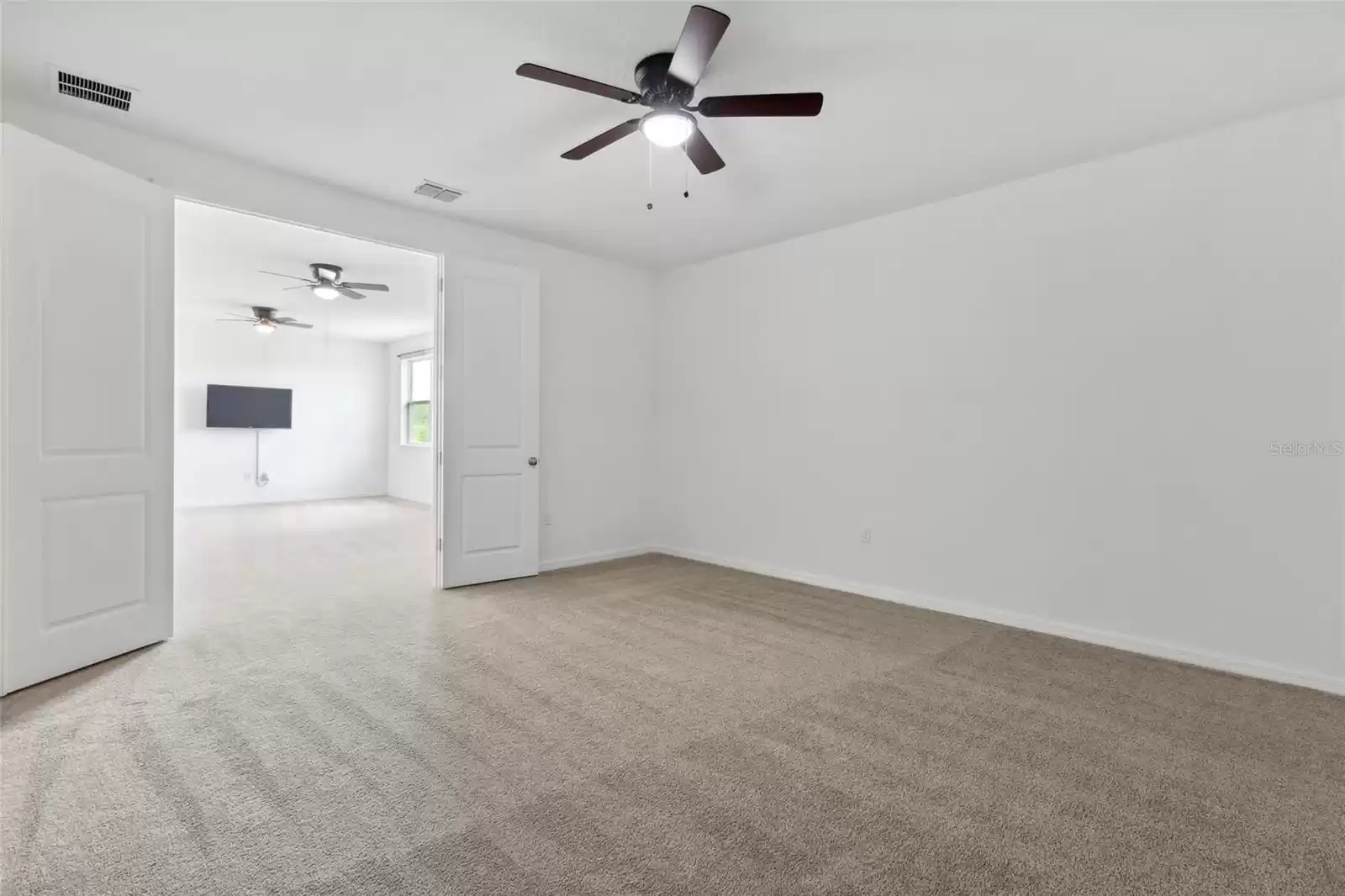 Right off the loft area is the media room with french doors and ceiling fan.