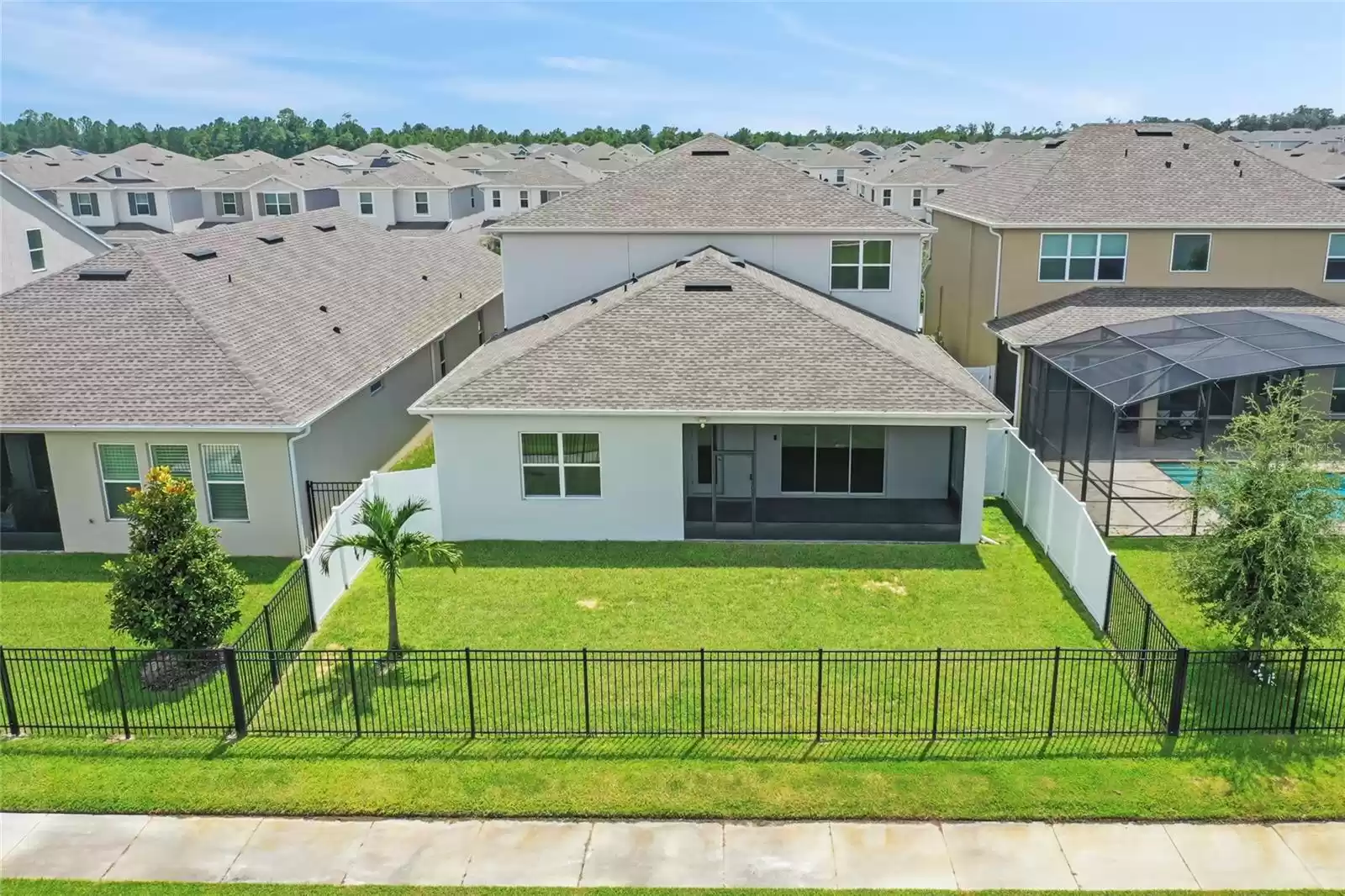 Aerial view of the back of the home and fenced yard.