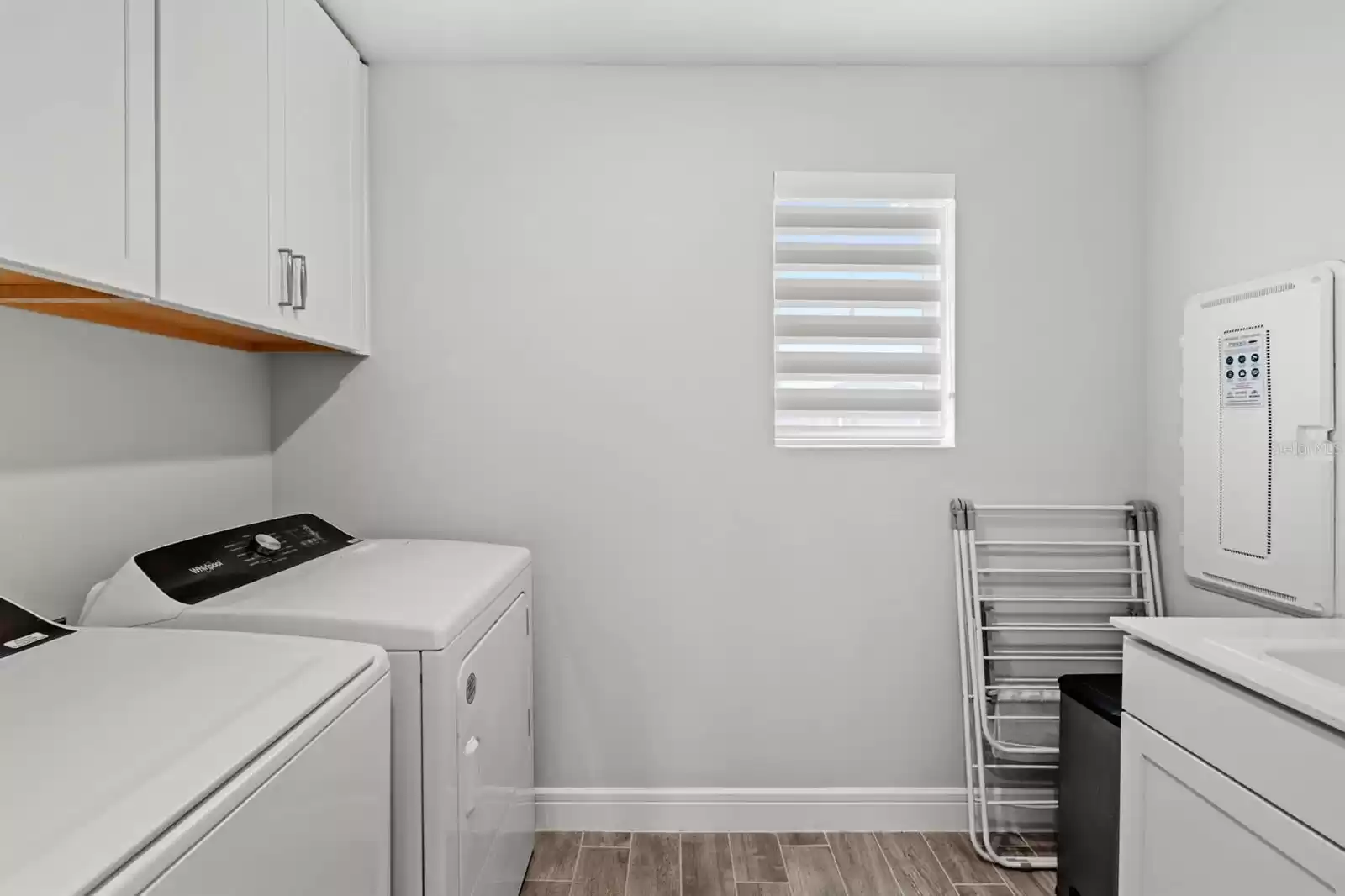 Laundry room with sink and overhead cabinets