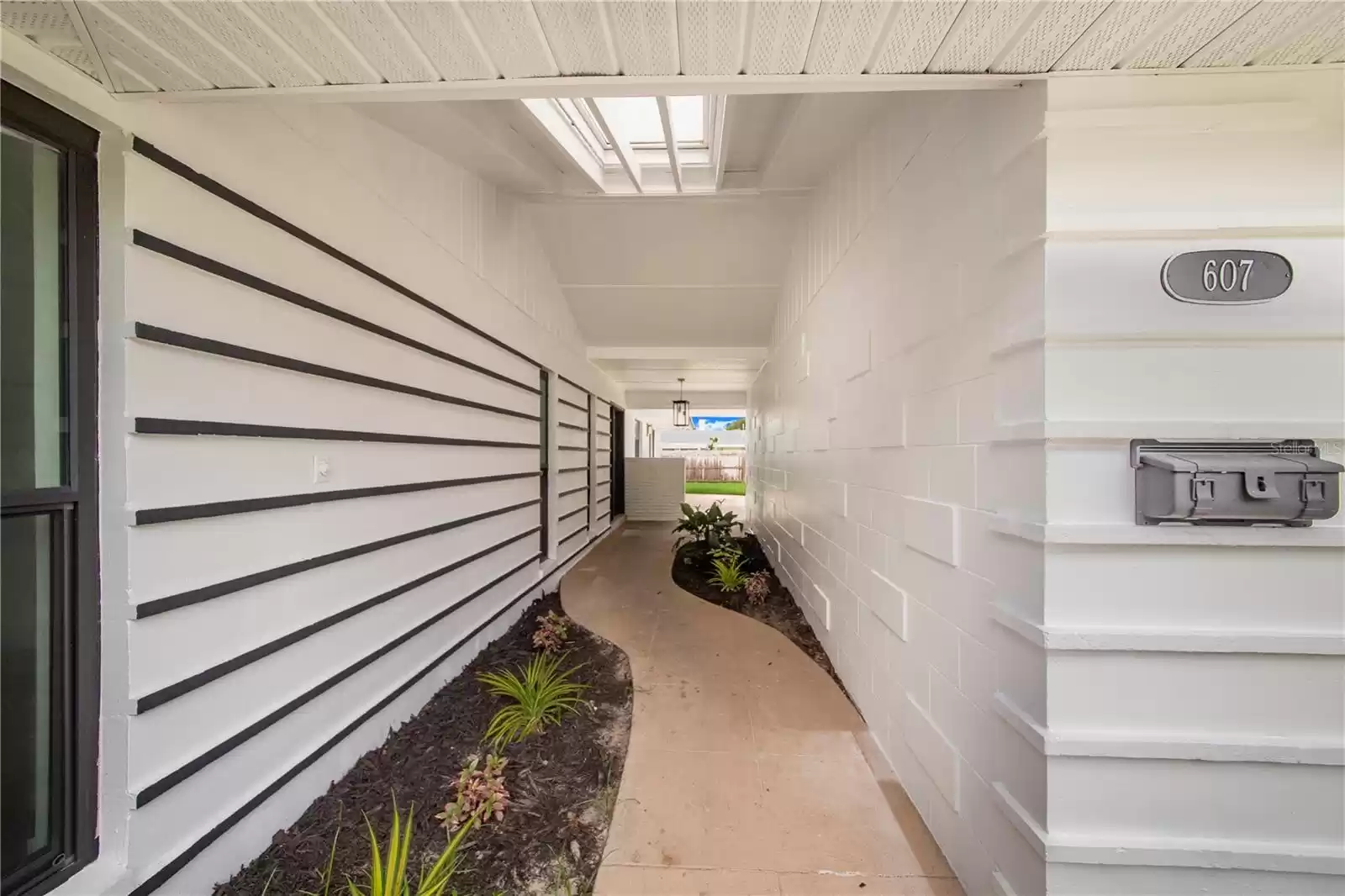 Covered entry way is very private and leads to front door, back yard and the oversized garage with storage cabinets