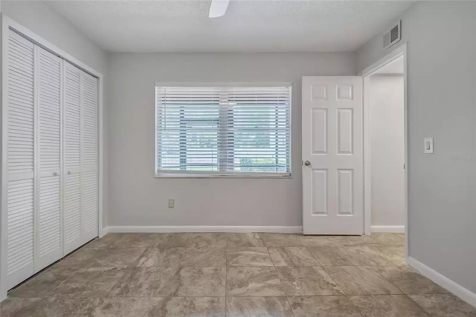 Second bedroom with newly painted walls, new ceiling fan.