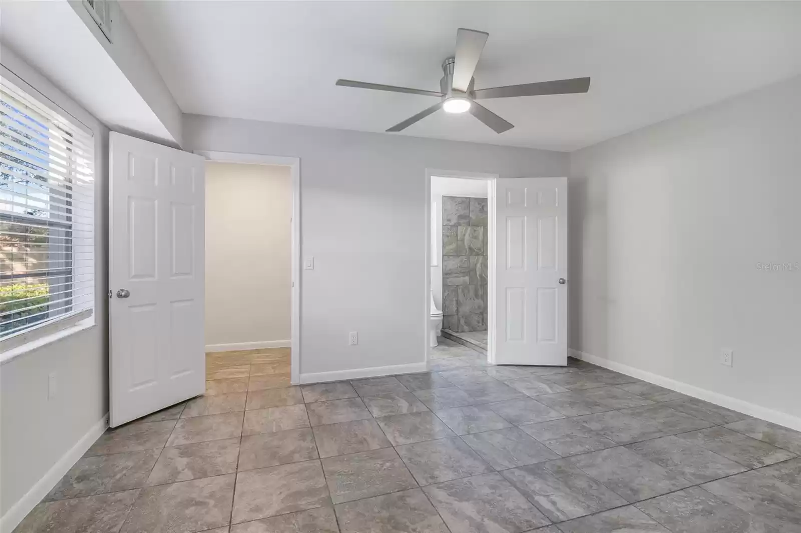 Another view of the master bedroom, new ceiling fan, newly painted walls and large walk in closet with ensuite master bath