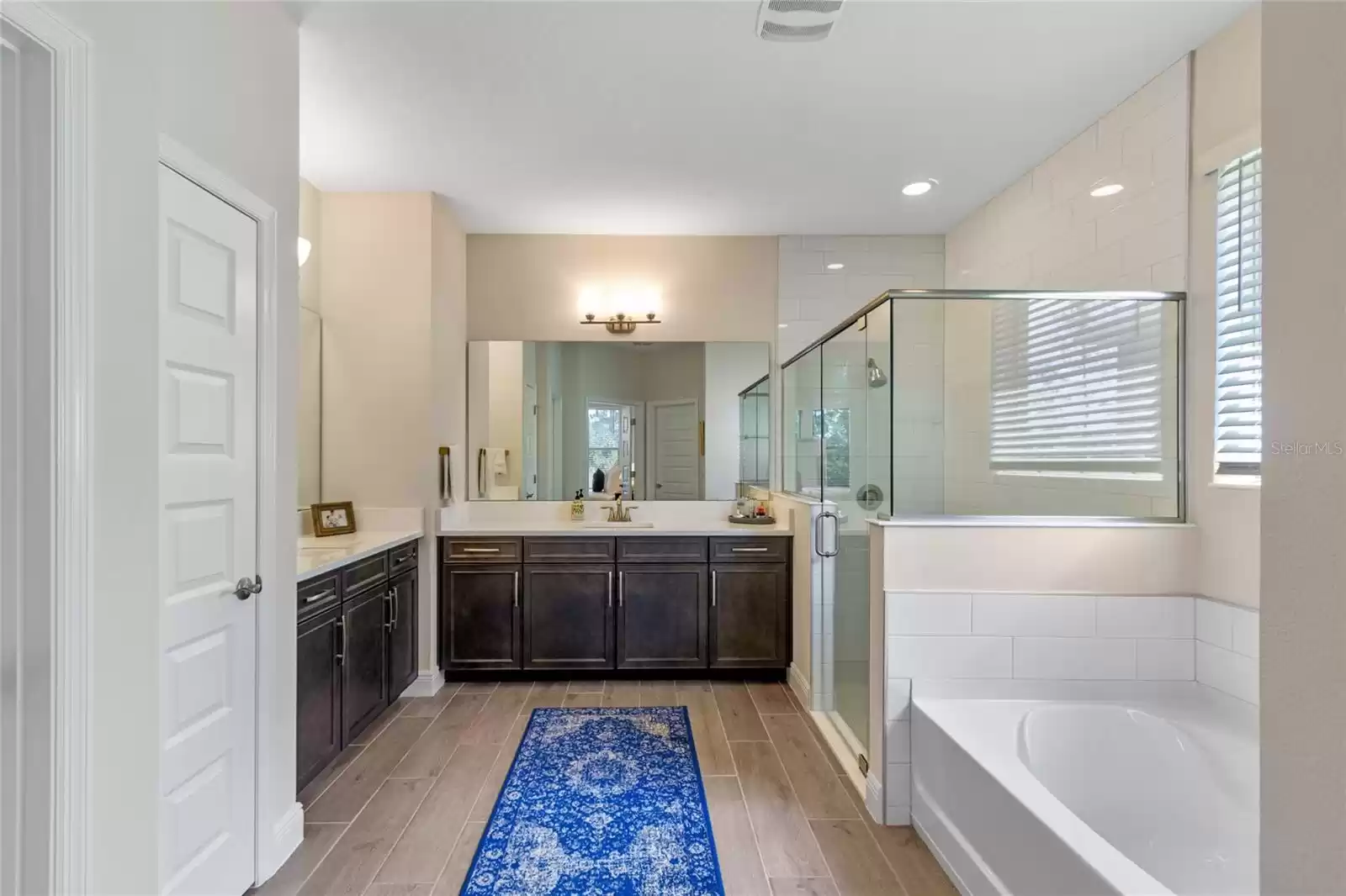 Spa primary bath with dual vanities, large walk in shower and soaking tub.