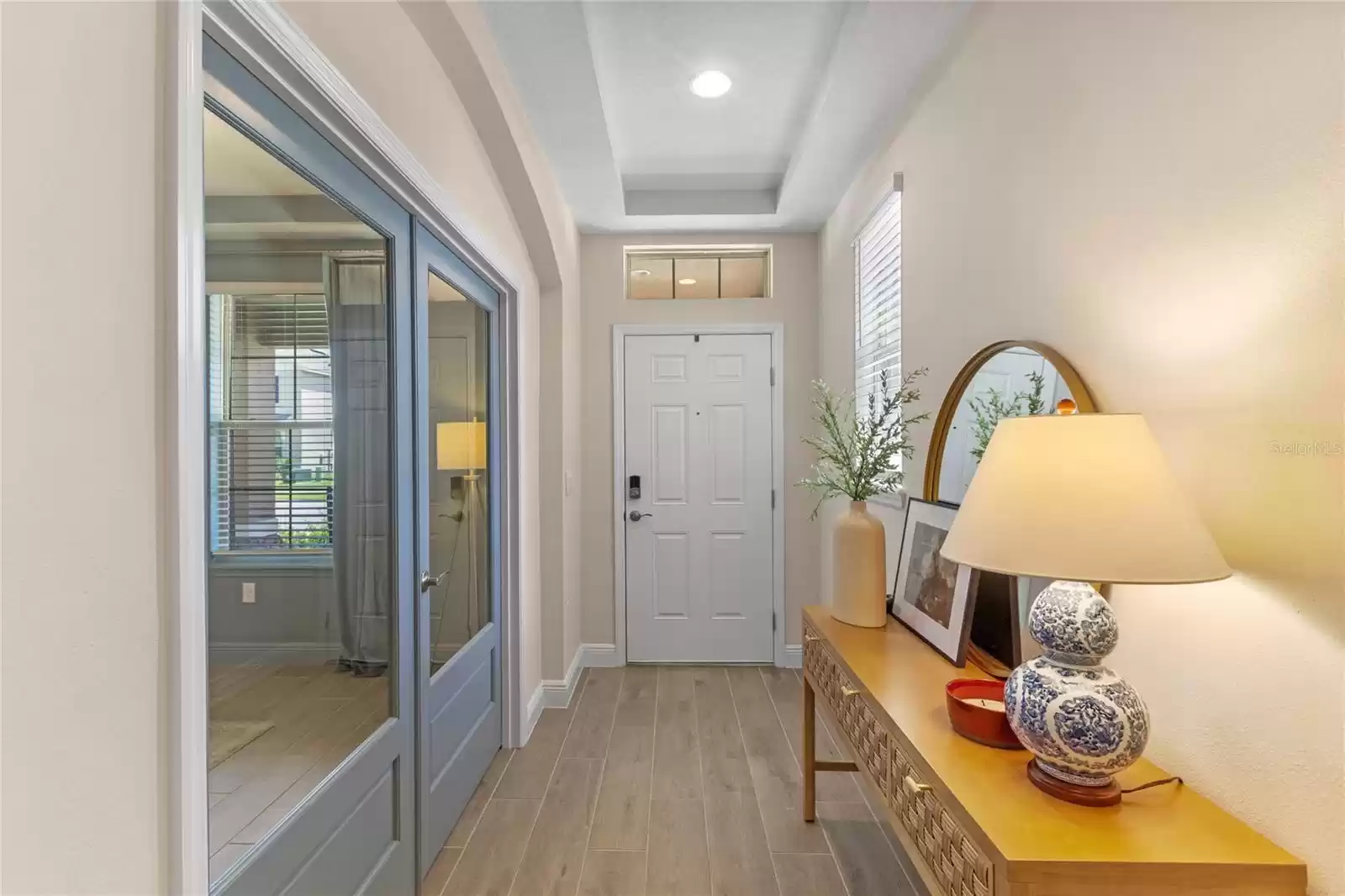 Light and bright foyer with window and tray ceiling.  Flex room with French doors for privacy.