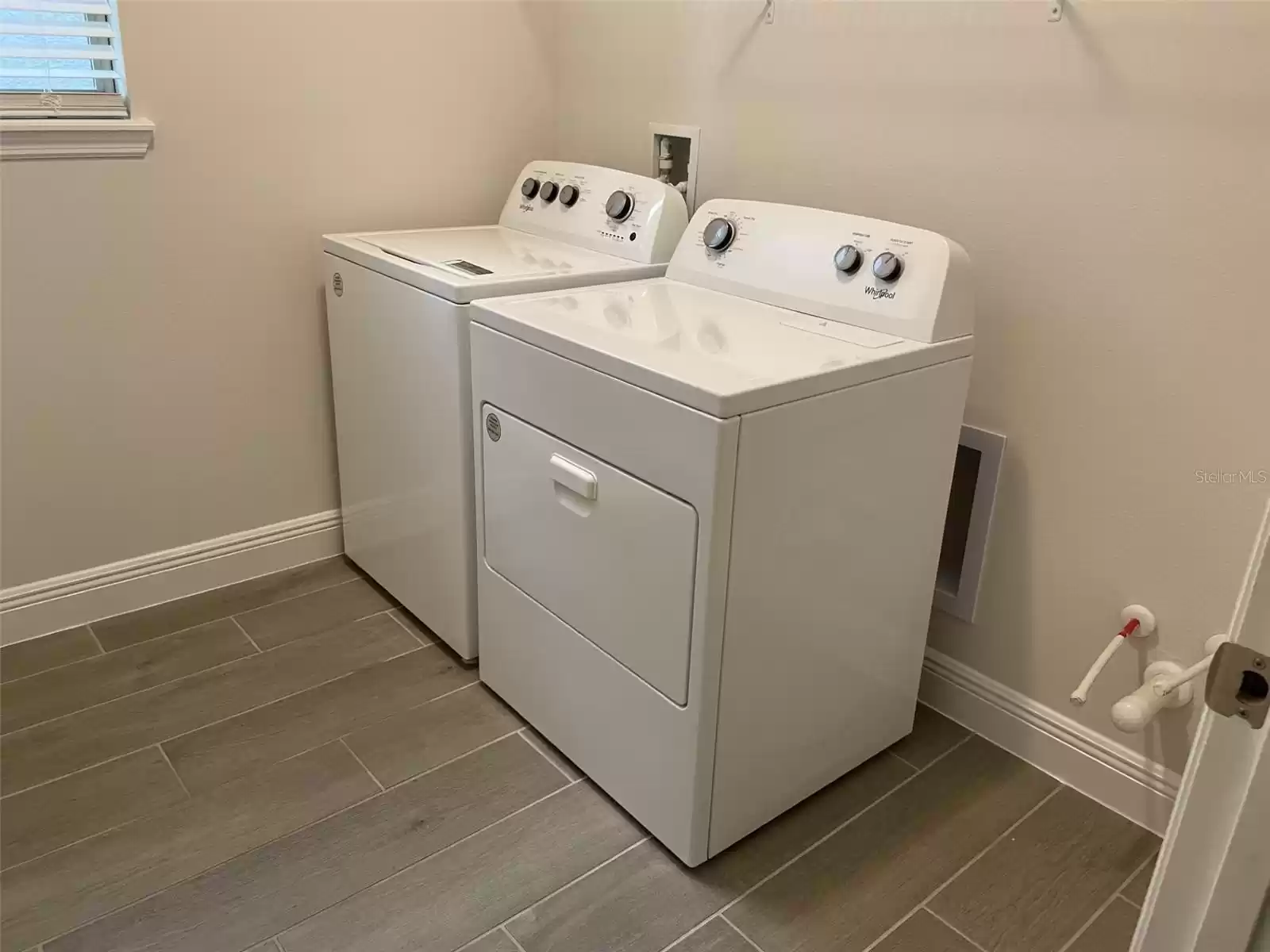 Laundry room is light and bright with a window. Brand new washer and dryer.