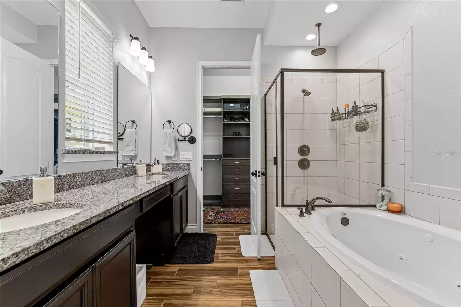 Primary bathroom with glass enclosed walk-in shower and garden tub.