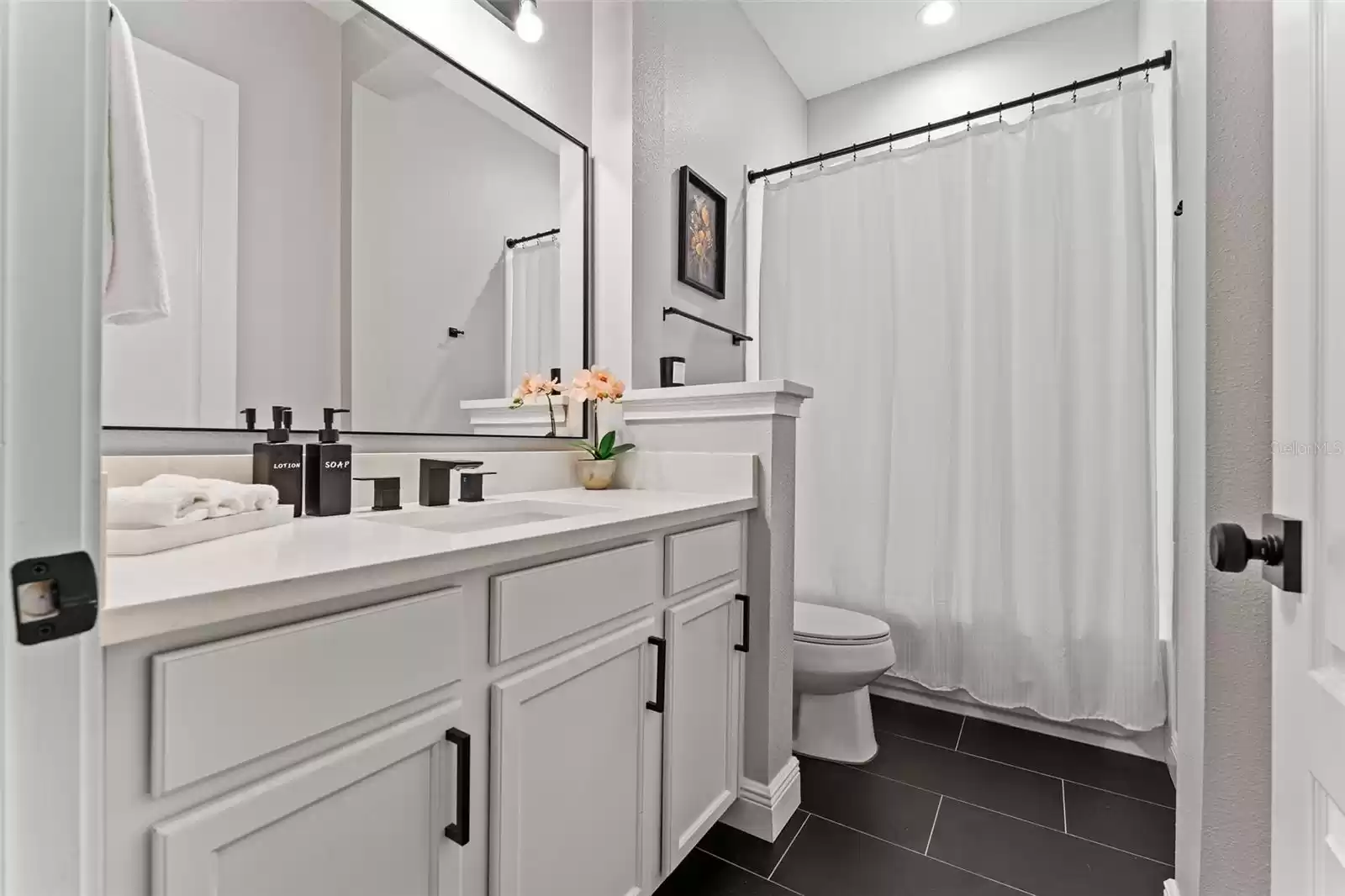 Bathroom 2 with single vanity and tub with shower.