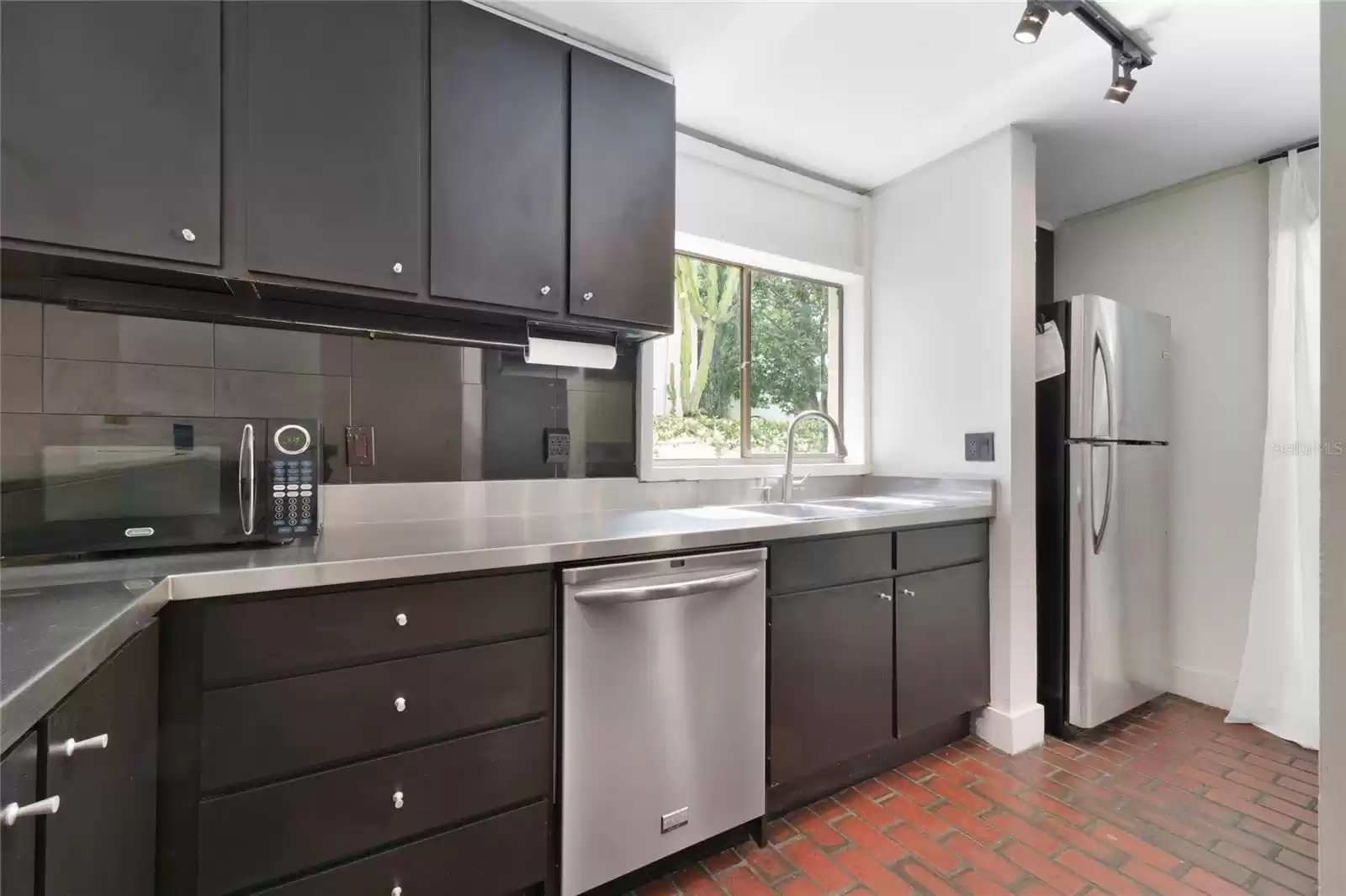 The kitchen is outfitted with stainless steel appliances and countertops and plenty of cabinetry.