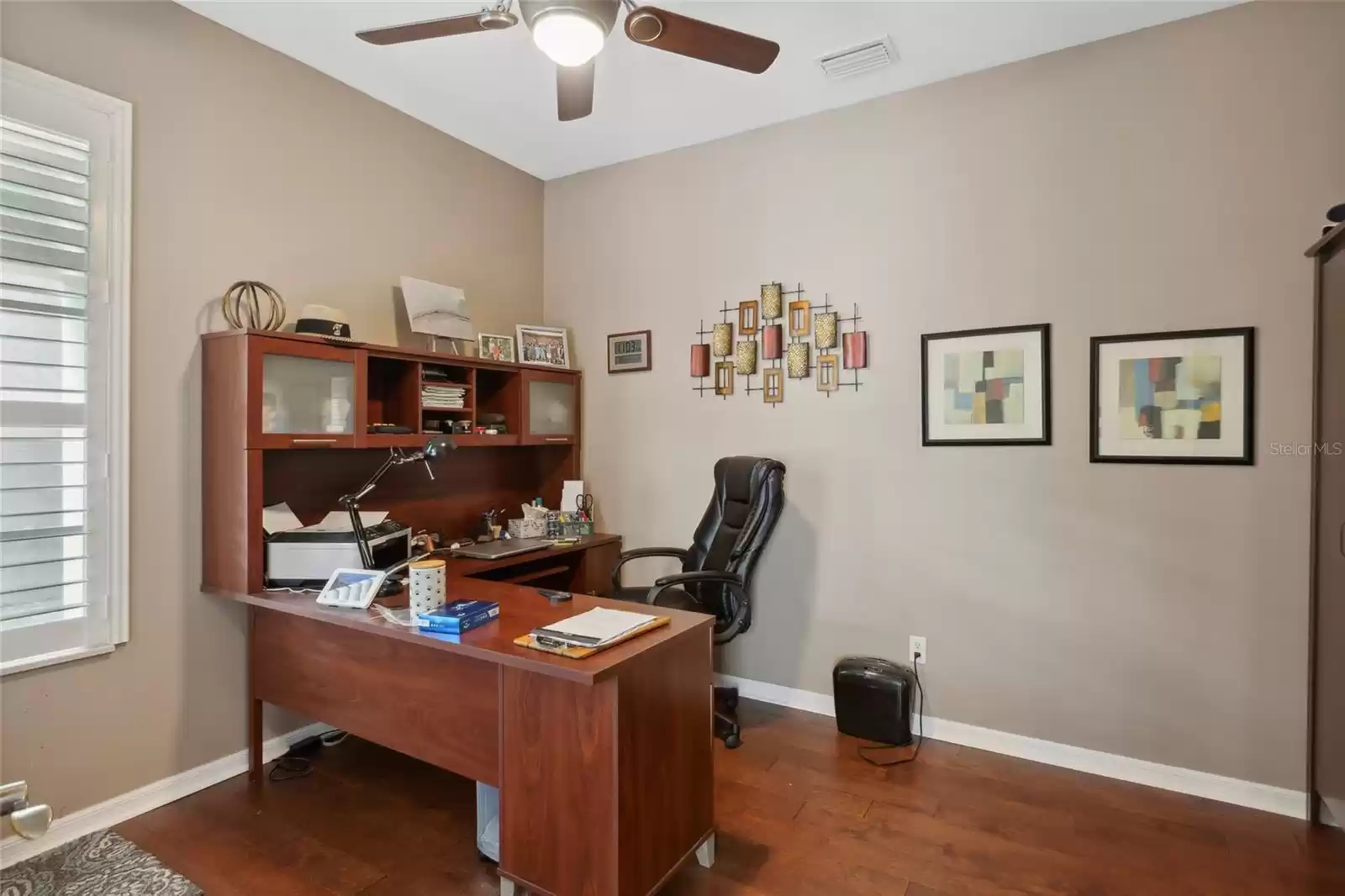 First floor office/den with newer wood flooring and a ceiling fan. The den is right off the main foyer.