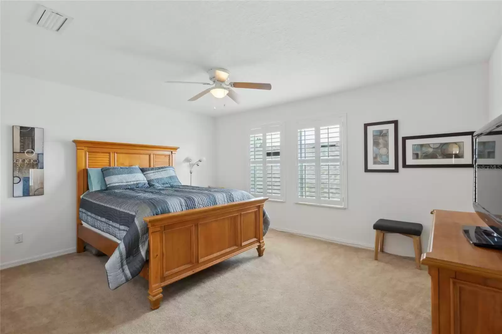 5th bedroom upstairs with ceiling fan and double closet extending the wall length.