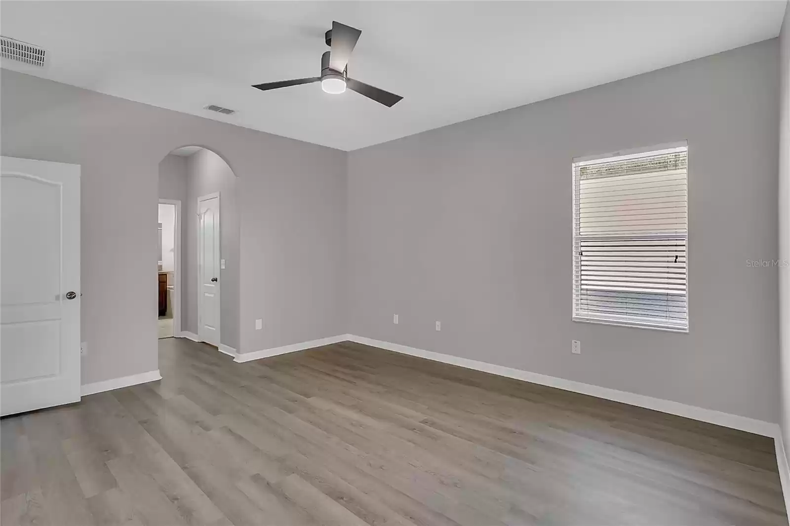 Primary bedroom with ceiling fan and ensuite master bath and 2 walk in closets