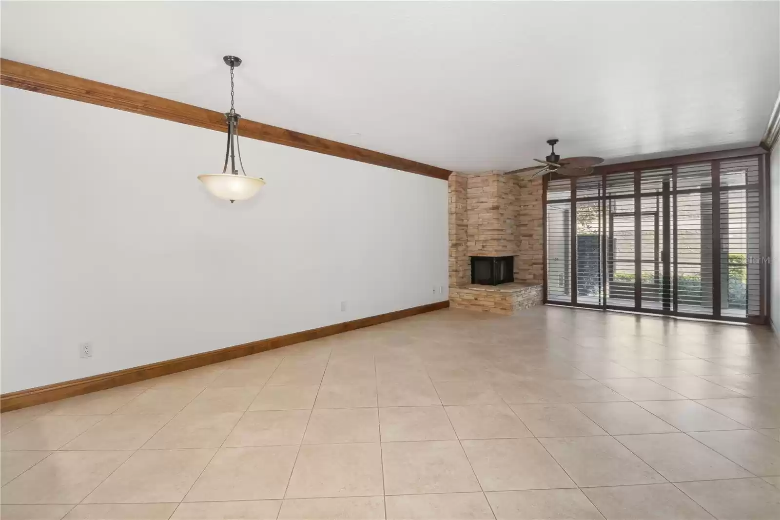 Living room / Dining room combo with fireplace and sliders to rear screened patio