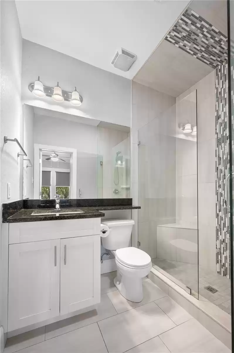 Primary ensuite bathroom with walk-in shower and floor to ceiling tile