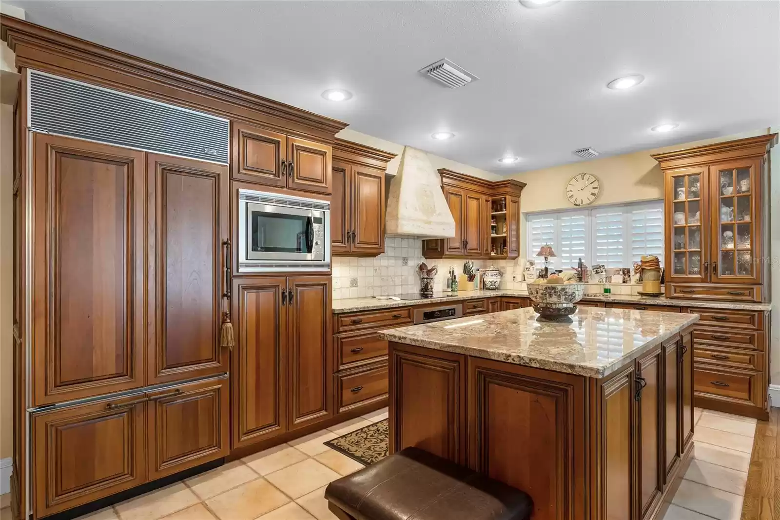 Gourmet kitchen with stainless appliances, custom solid wood cabinetry and stone counters