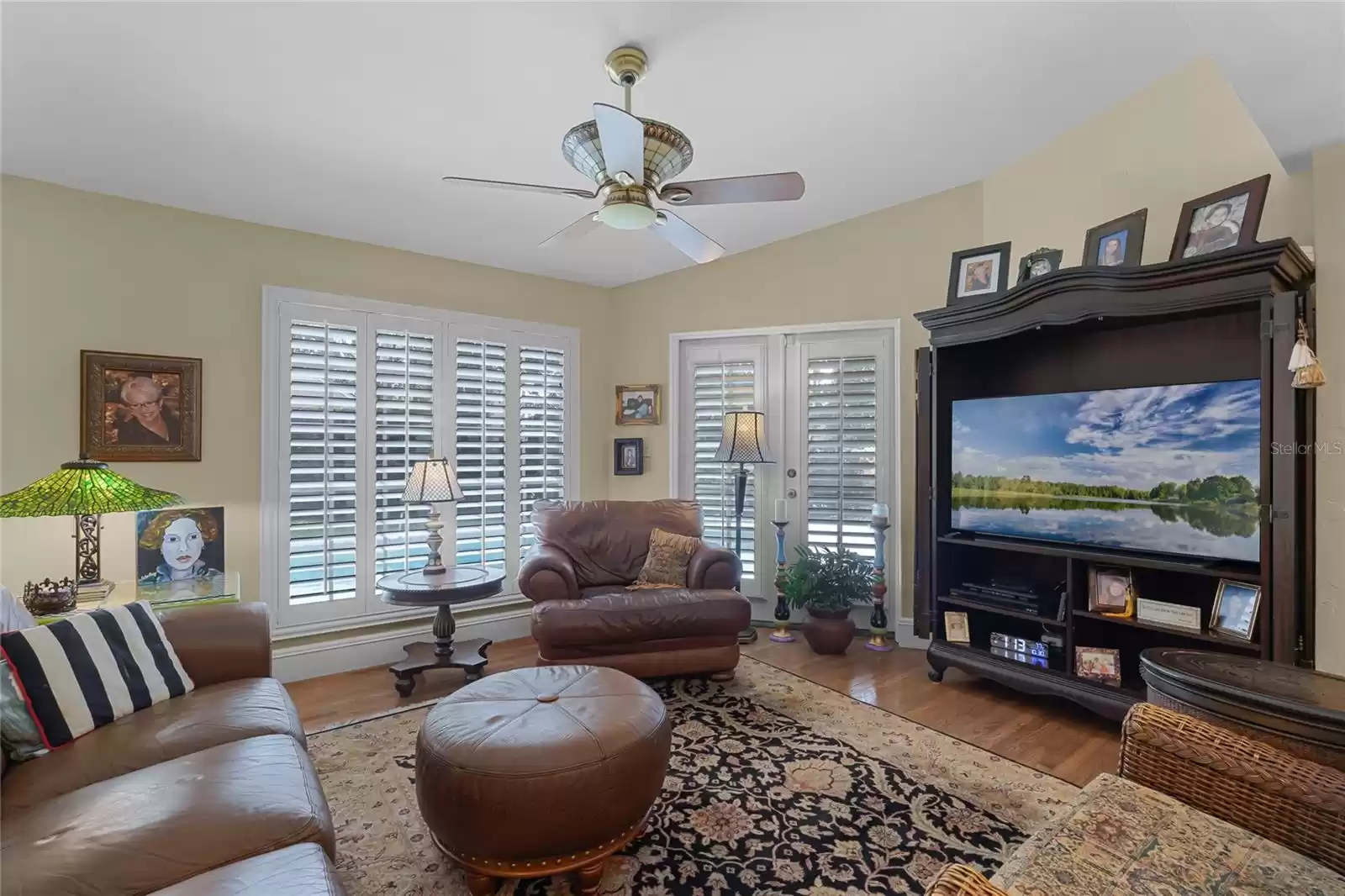 Comfortable family room with windows and french doors out to the pool and backyard