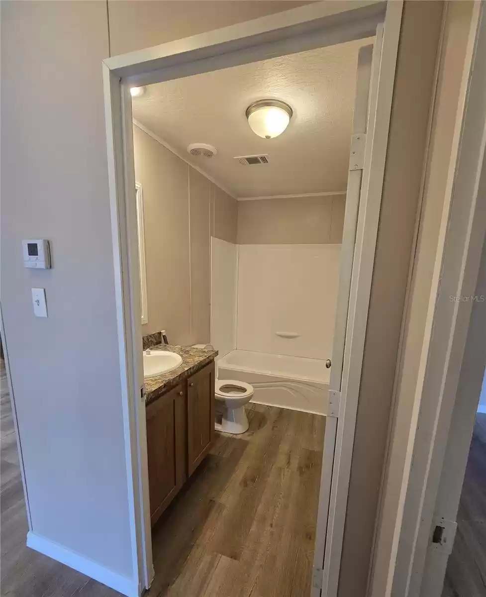 The home's second bathroom is conveniently located for guests and tenants alike, featuring a tub/shower combo.