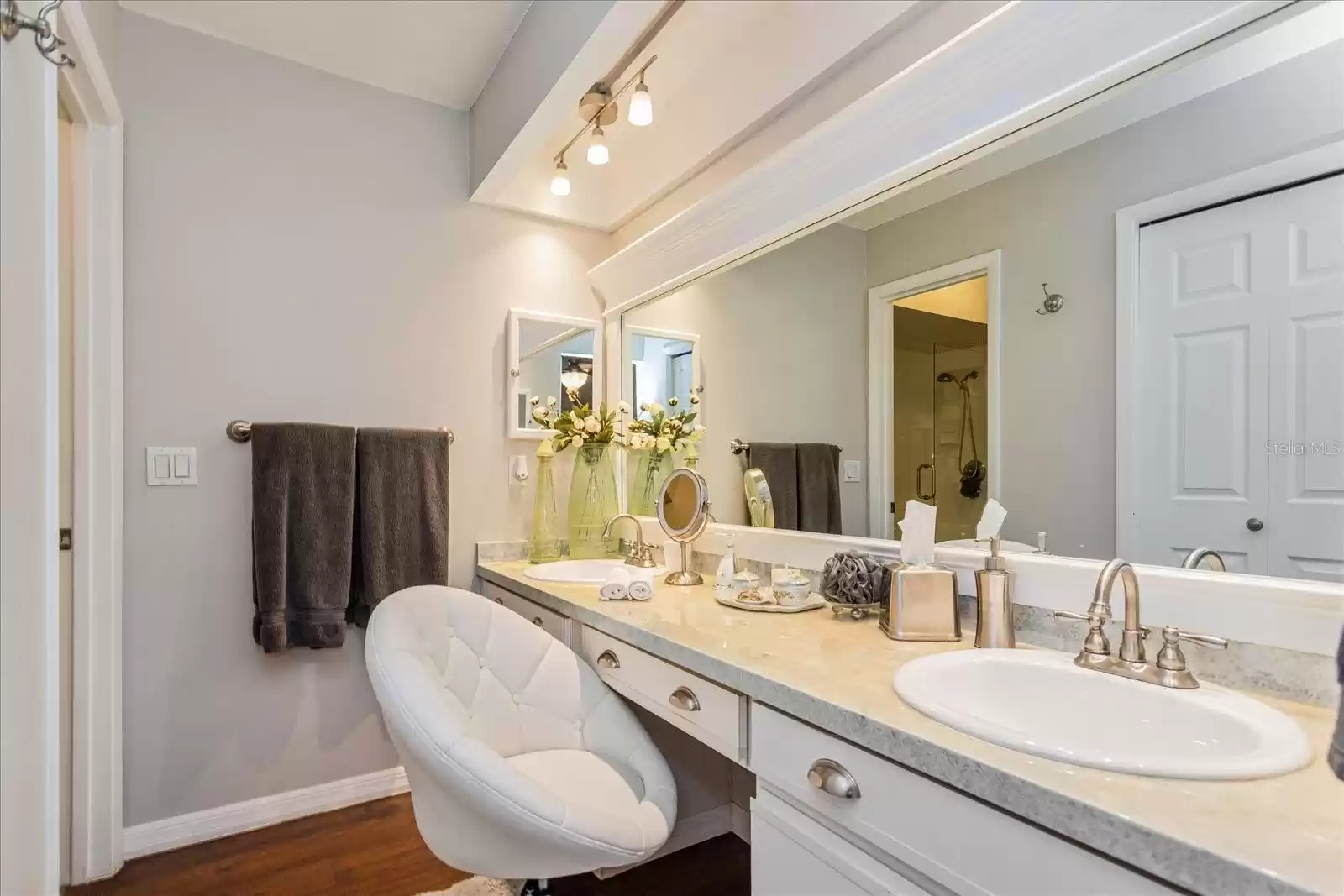 Dressing area with dual sinks included across from walk-in primary closet and bathing room.