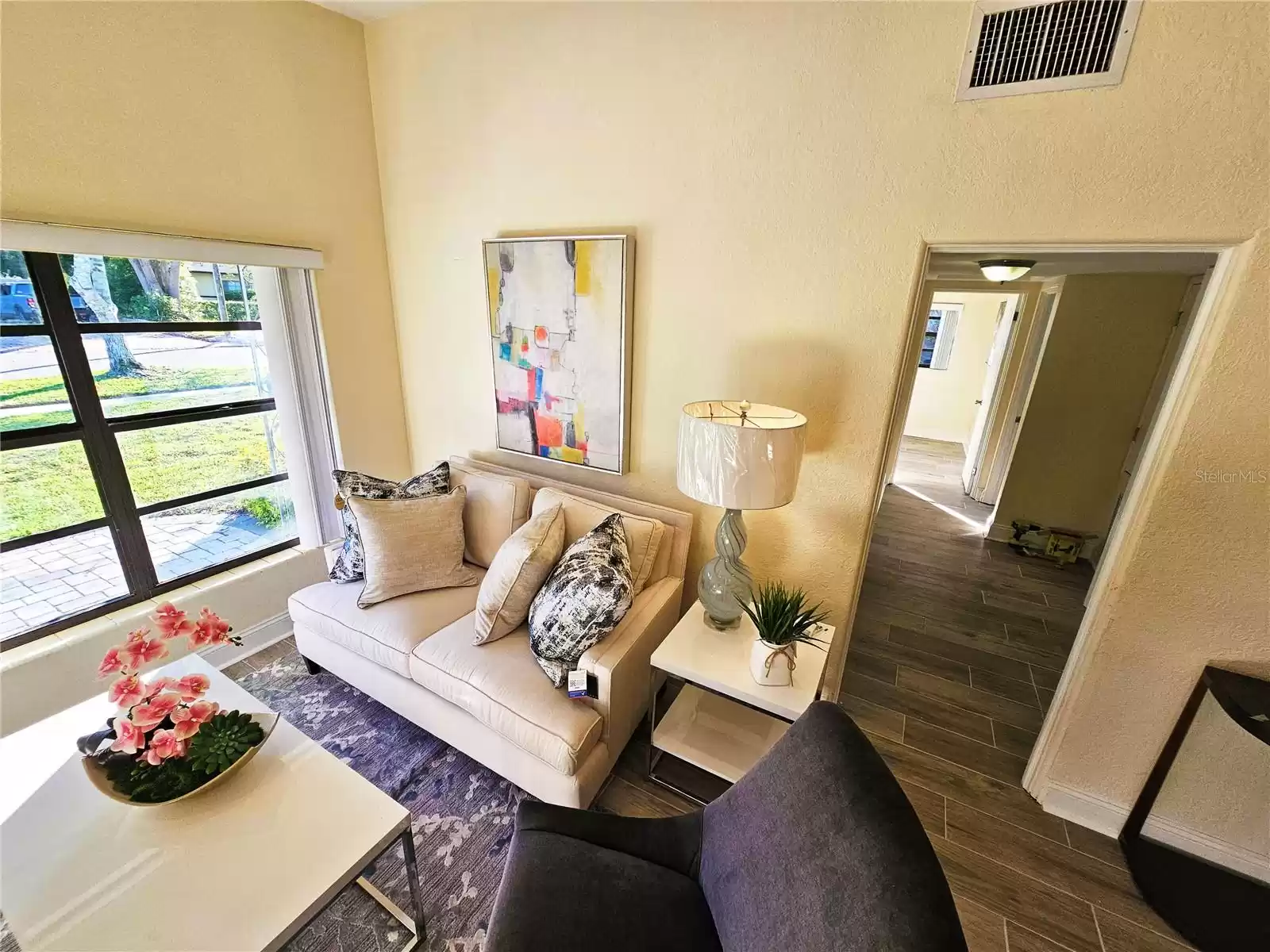 Living room with view of the front yard and the hallway