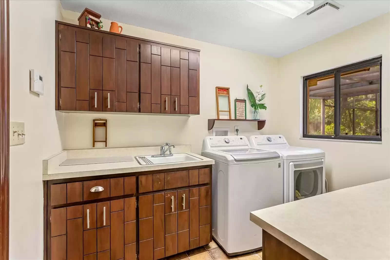 Laundry with sink, dual counters, cabinets plus LG washer-dryer