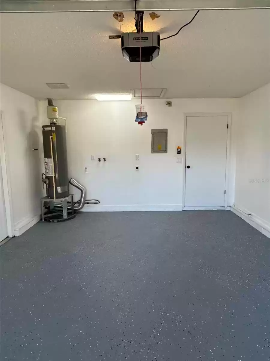 Garage with gas water heater and laundry area