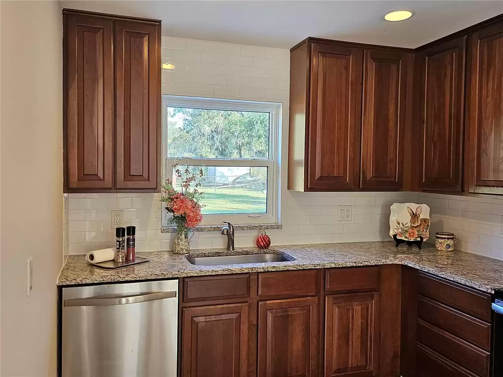 The kitchen features granite countertops and stainless steel farm sink.