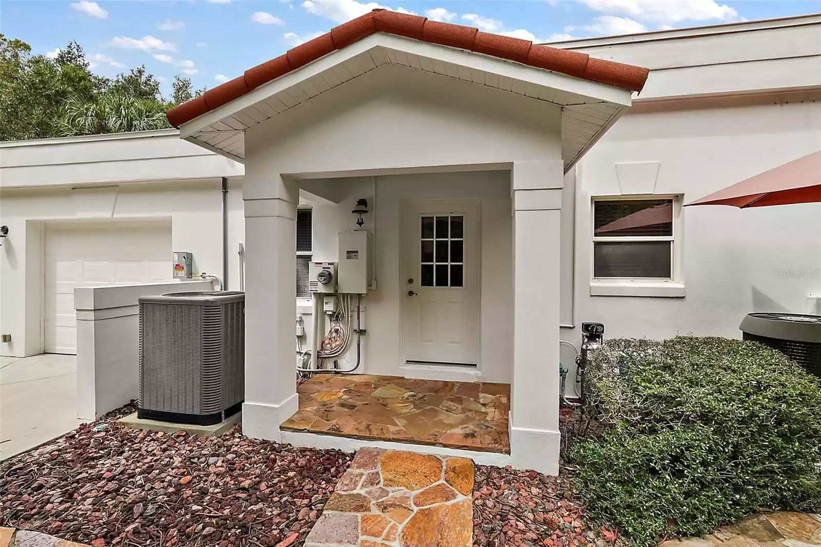 A side entry off the garage houses many of the home's utility systems, including the pool's solar heater and pump. Nearby are the generator and irrigation well head.