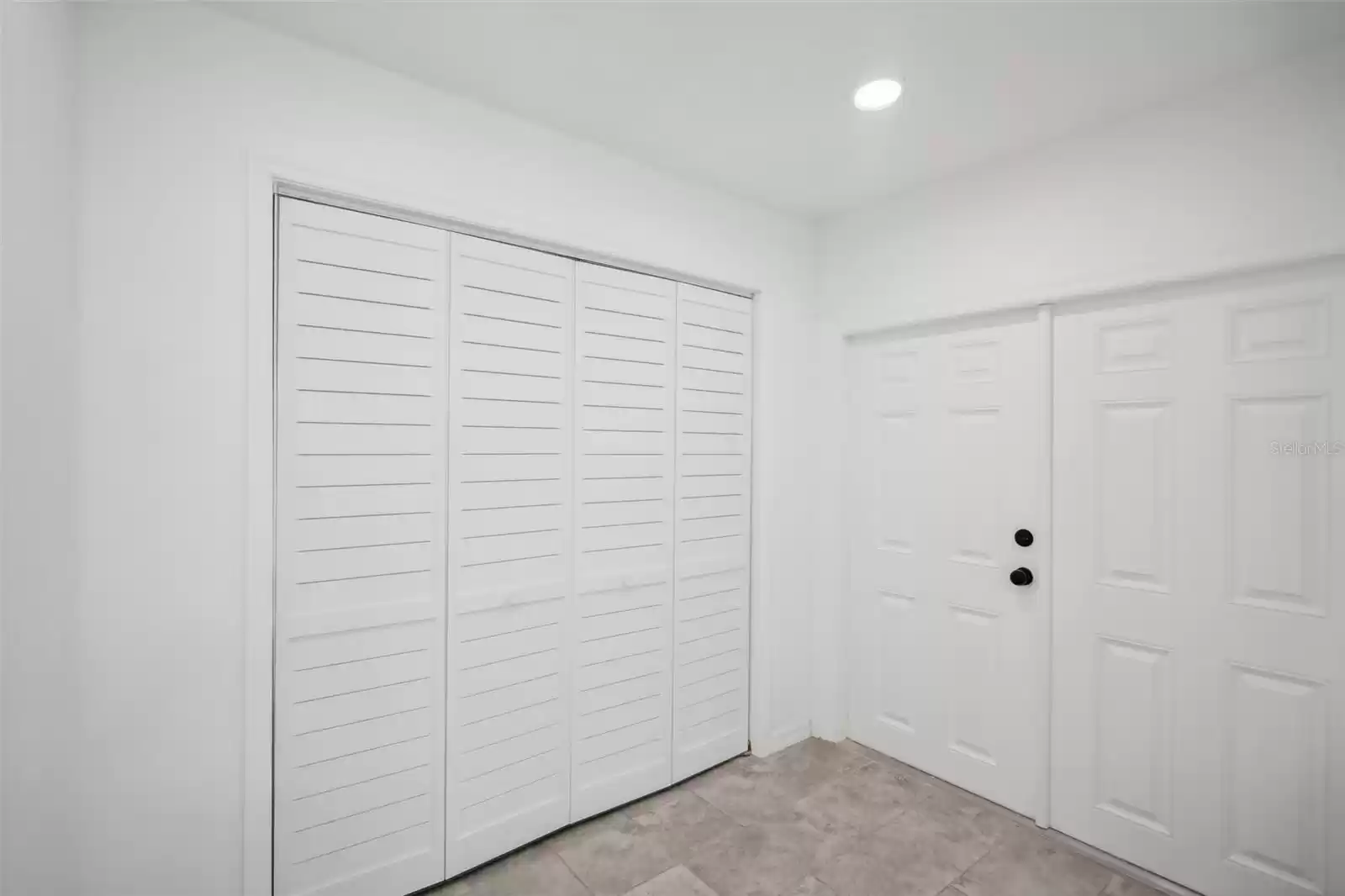 Primary closet. French doors to backyard.