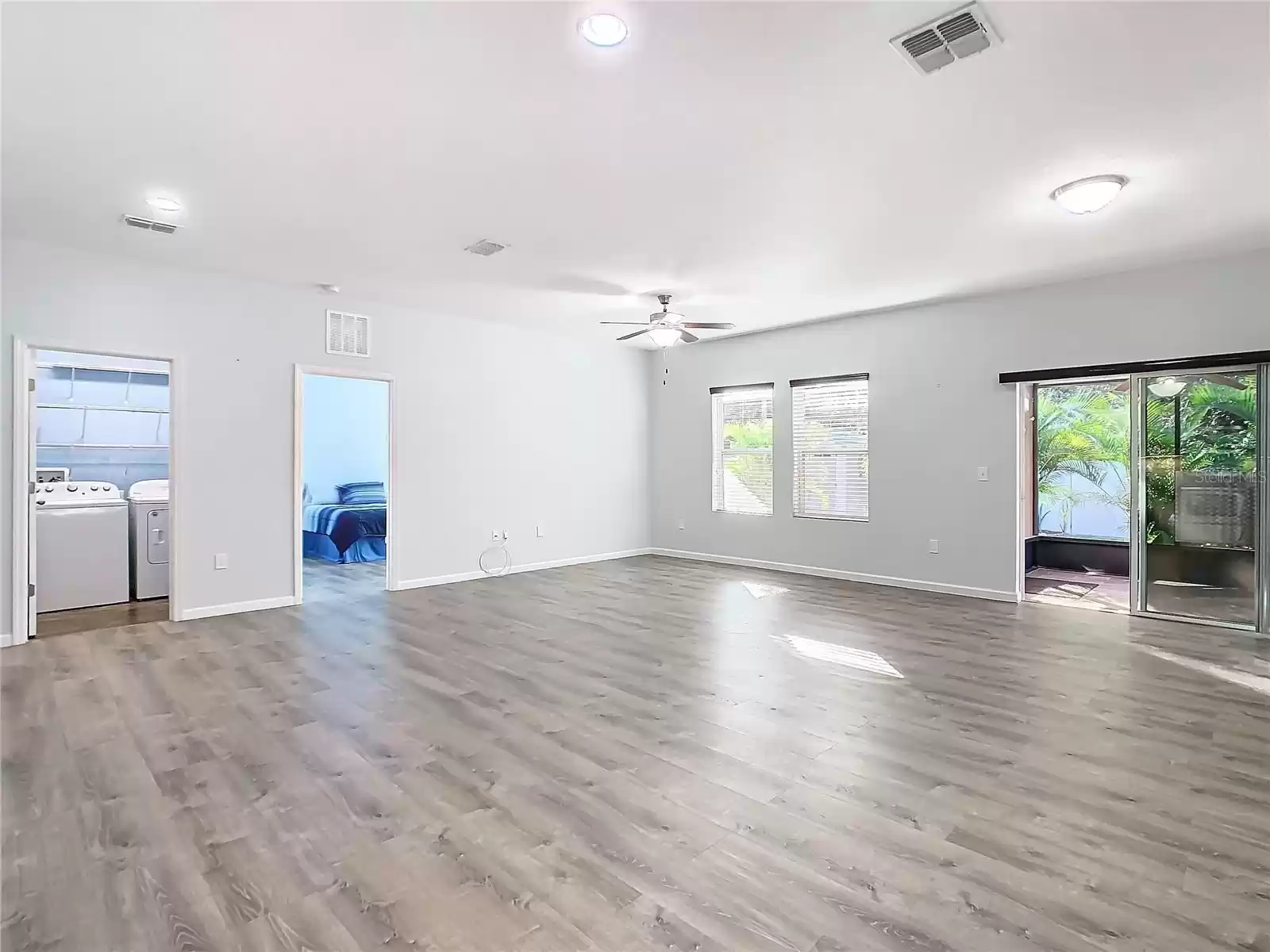 Living room with ceiling fan/light, recessed lighting and the privacy of your own backyard retreat.