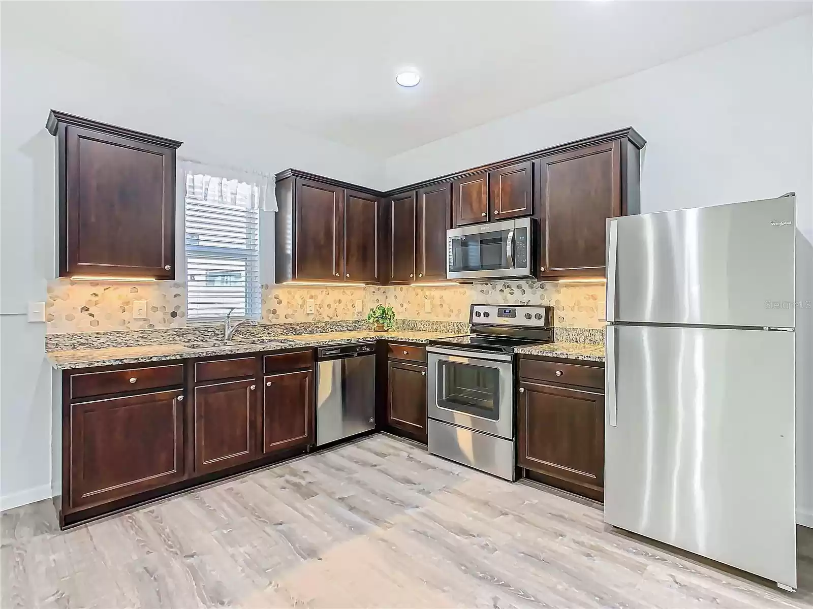 The kitchen has been upgraded with granite countertops, stone backsplash and under cabinet lighting.