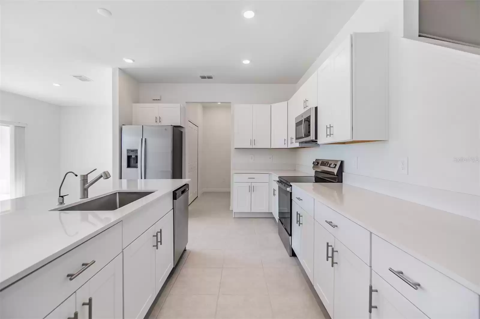 Functional kitchen with white cabinets & stainless hardware