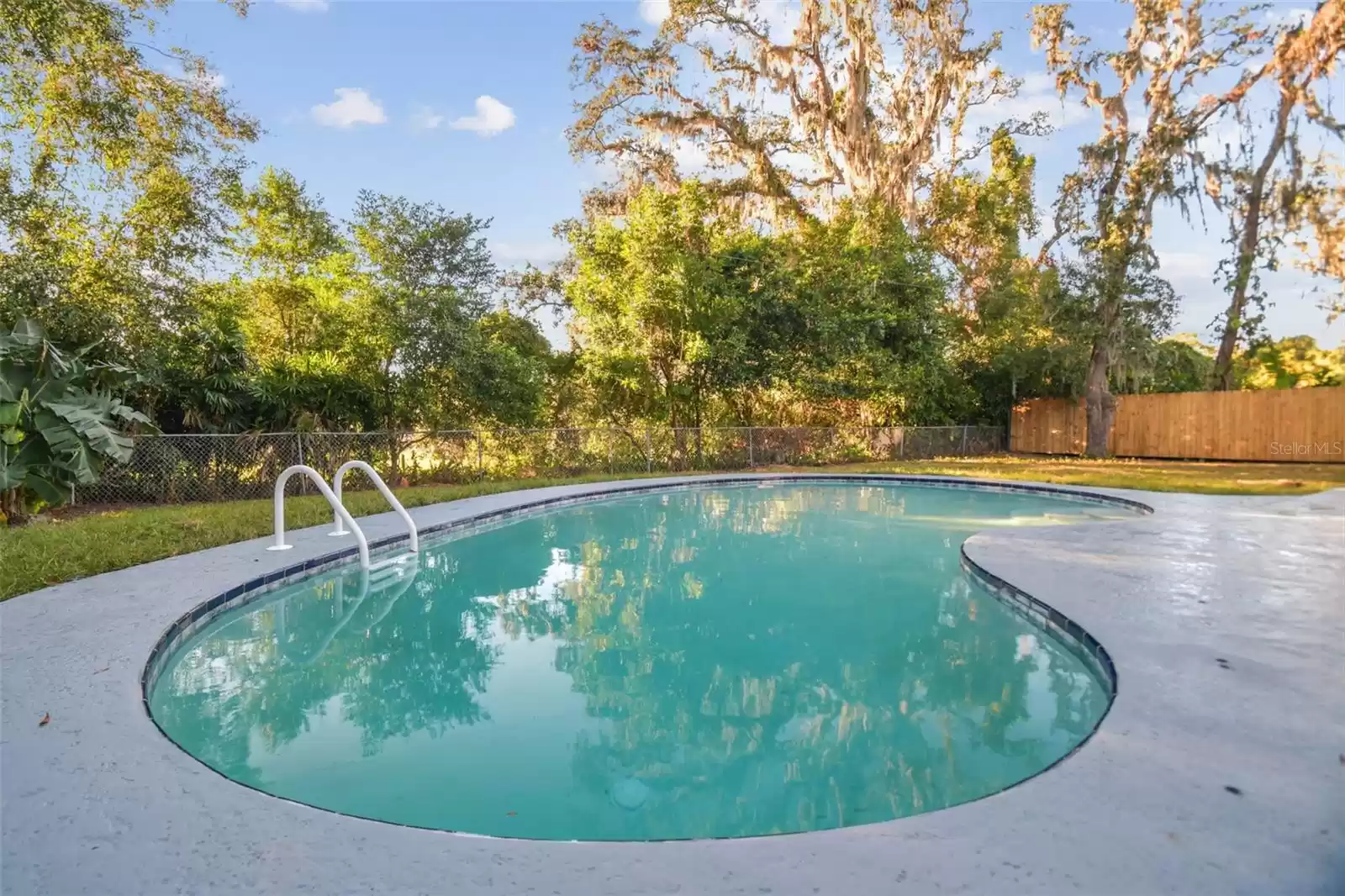 Fenced in backyard with lots of surrounding trees