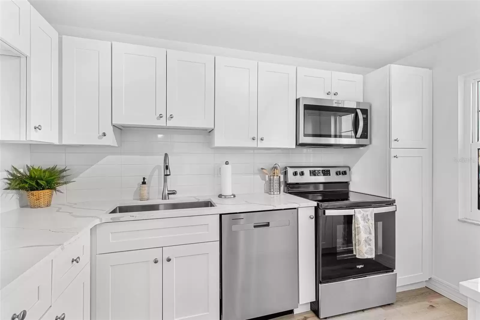 Gorgeous custom kitchen with quartz counters, stainless appliances and luxury vinyl flooring.