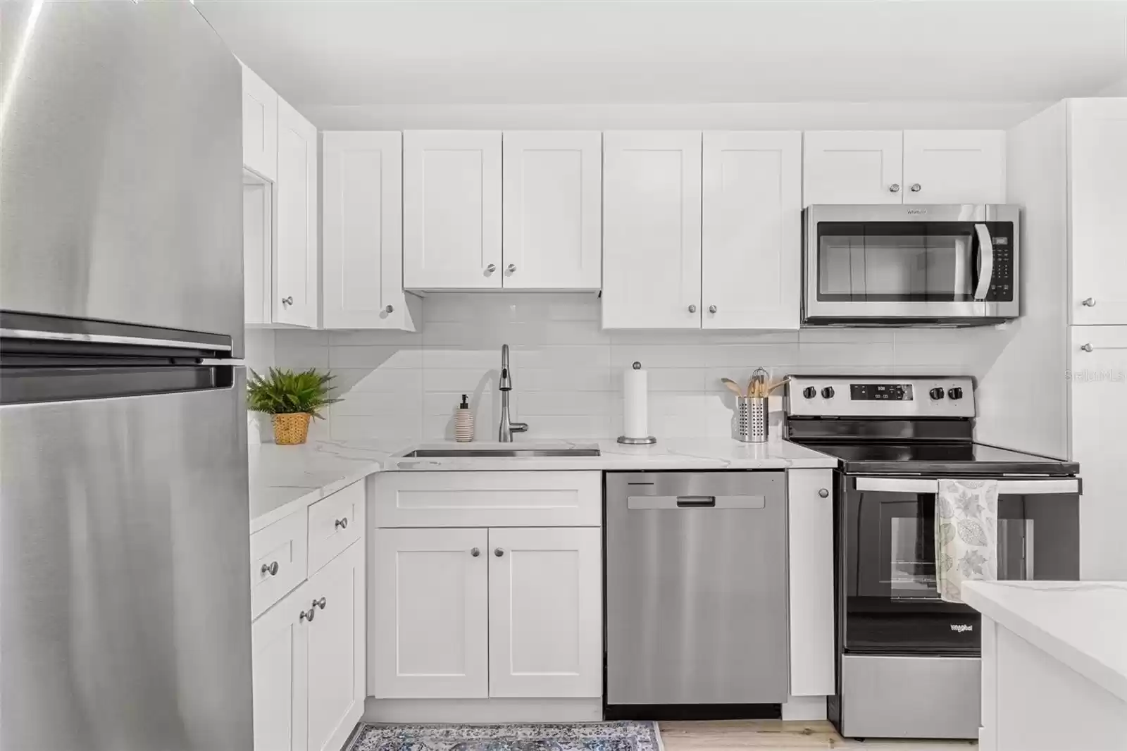 Gorgeous custom kitchen with quartz counters, stainless appliances and luxury vinyl flooring.