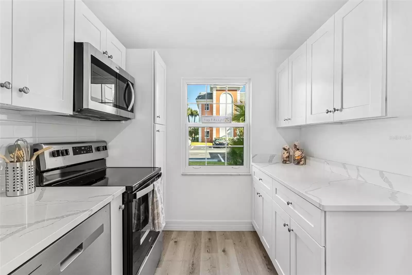 Gorgeous custom kitchen with quartz counters, stainless appliances and luxury vinyl flooring.