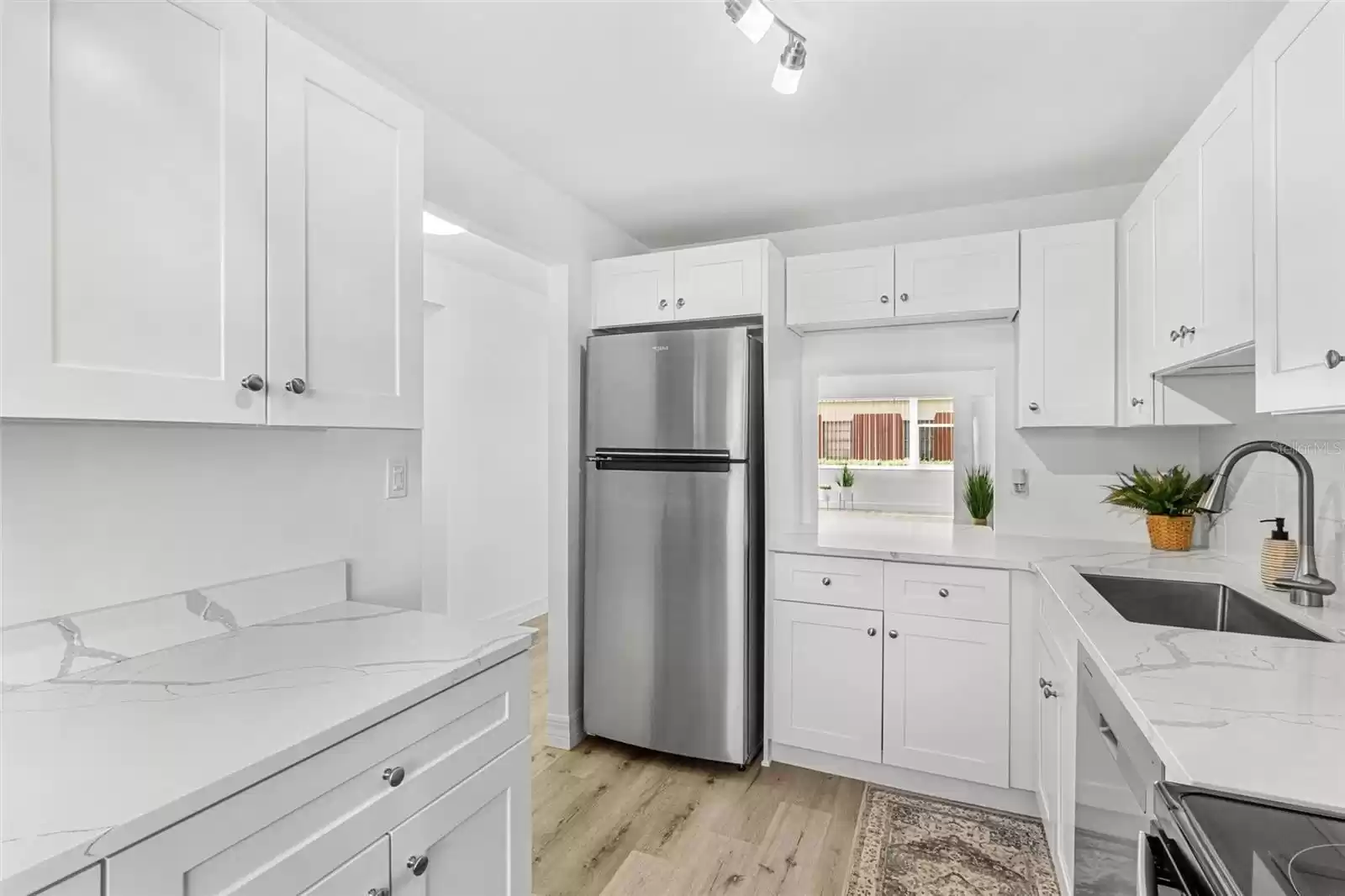 Gorgeous custom kitchen with quartz counters, stainless appliances and luxury vinyl flooring.